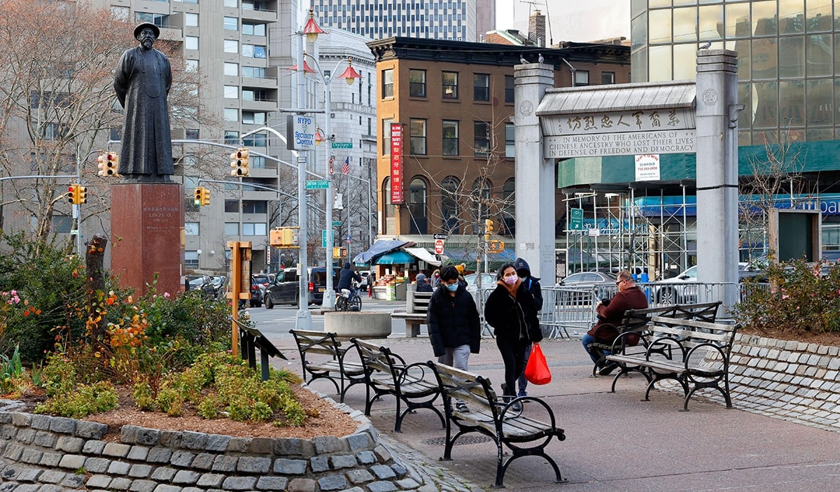 Two people walking through Kimlau Square in New York City